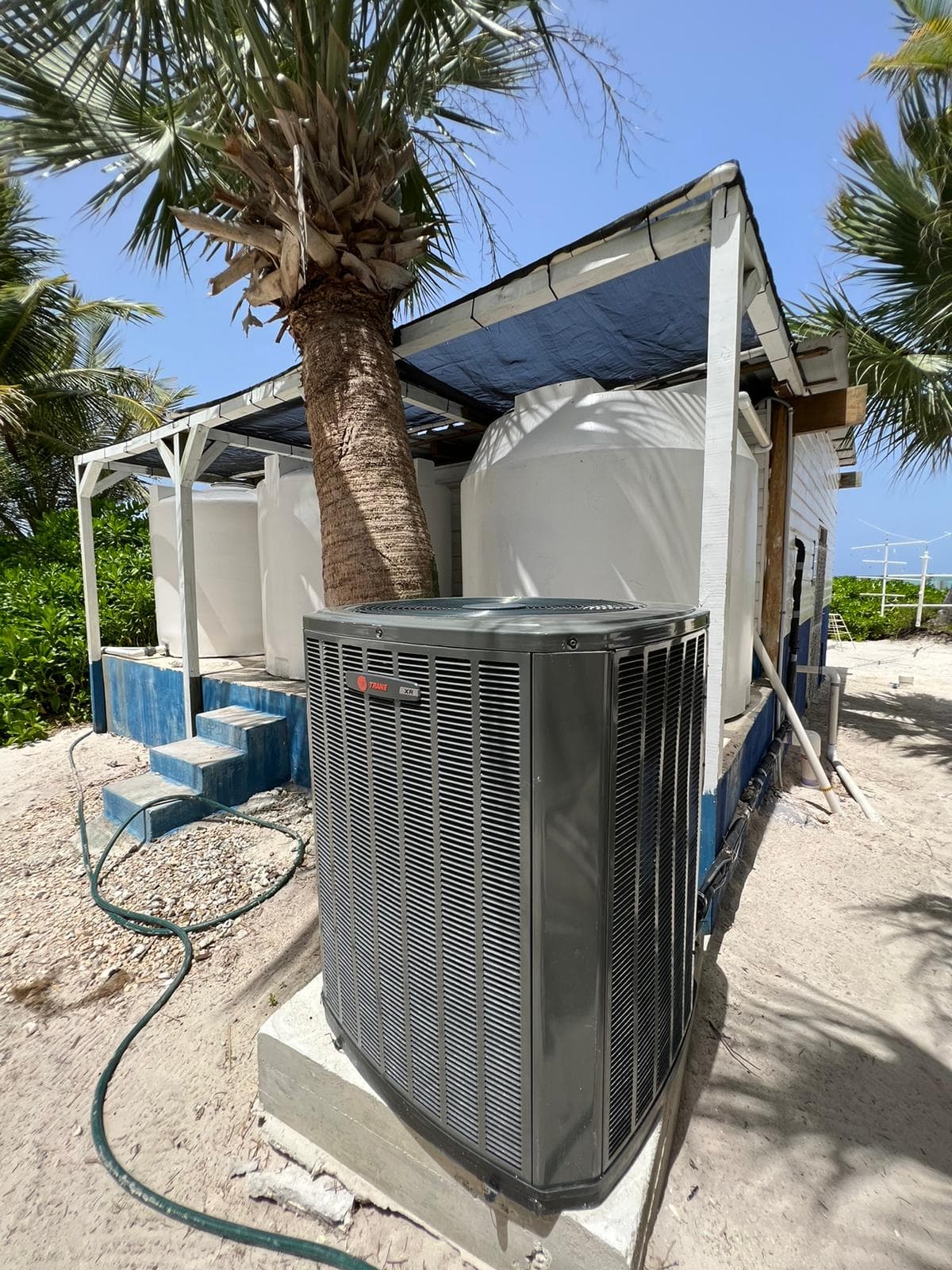Weather-rated air conditioner with seawater storage tanks